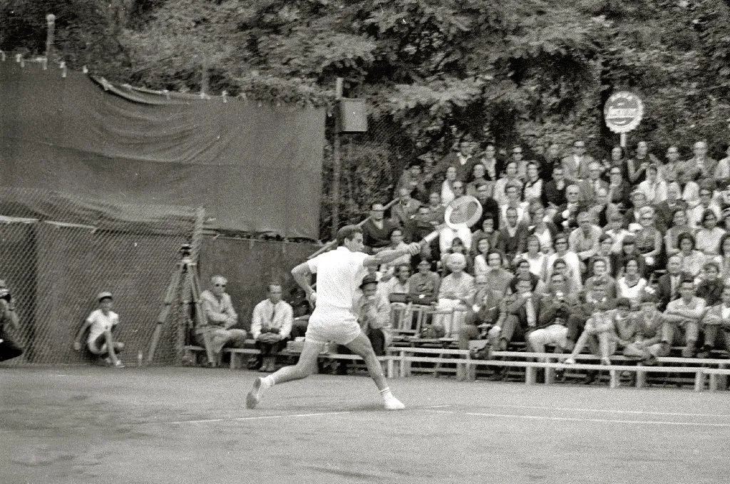 Manolo Santana frappe un coup droit lors d’un match de Coupe Davis en 1966, devant une tribune pleine