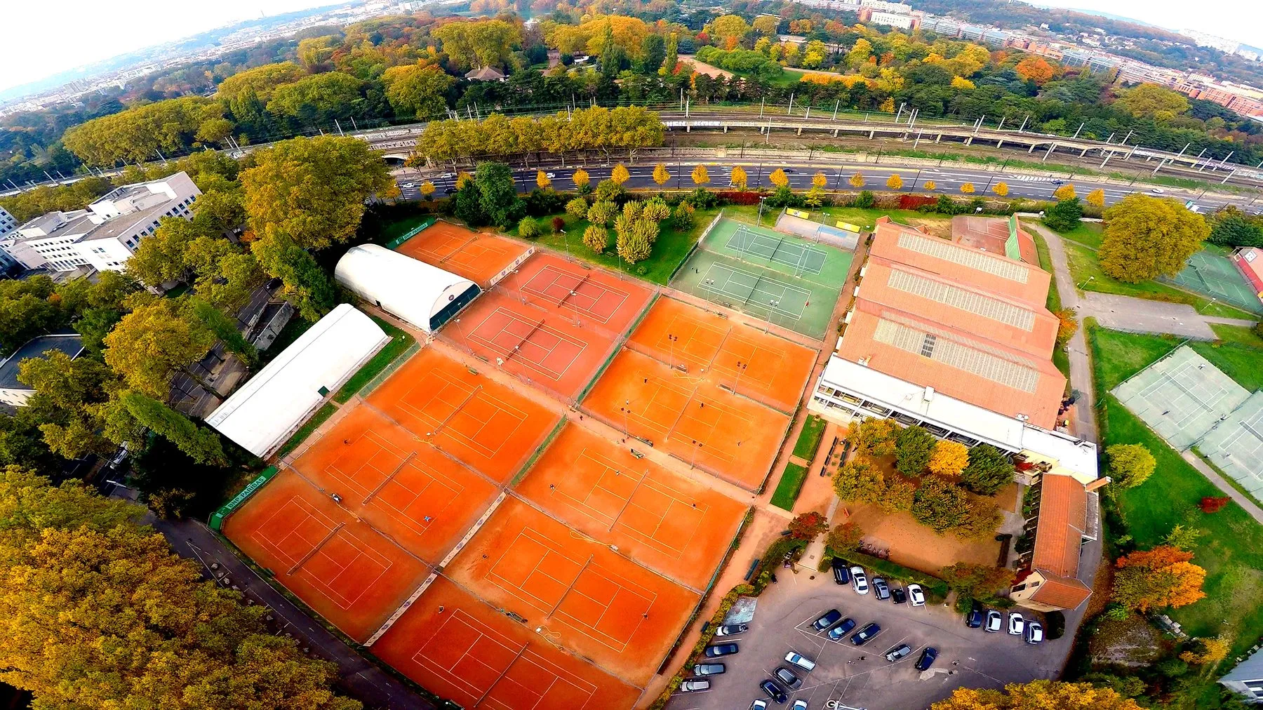 Vue aérienne du Tennis Club de Lyon, avec ses courts en terre battue et en dur au milieu des arbres