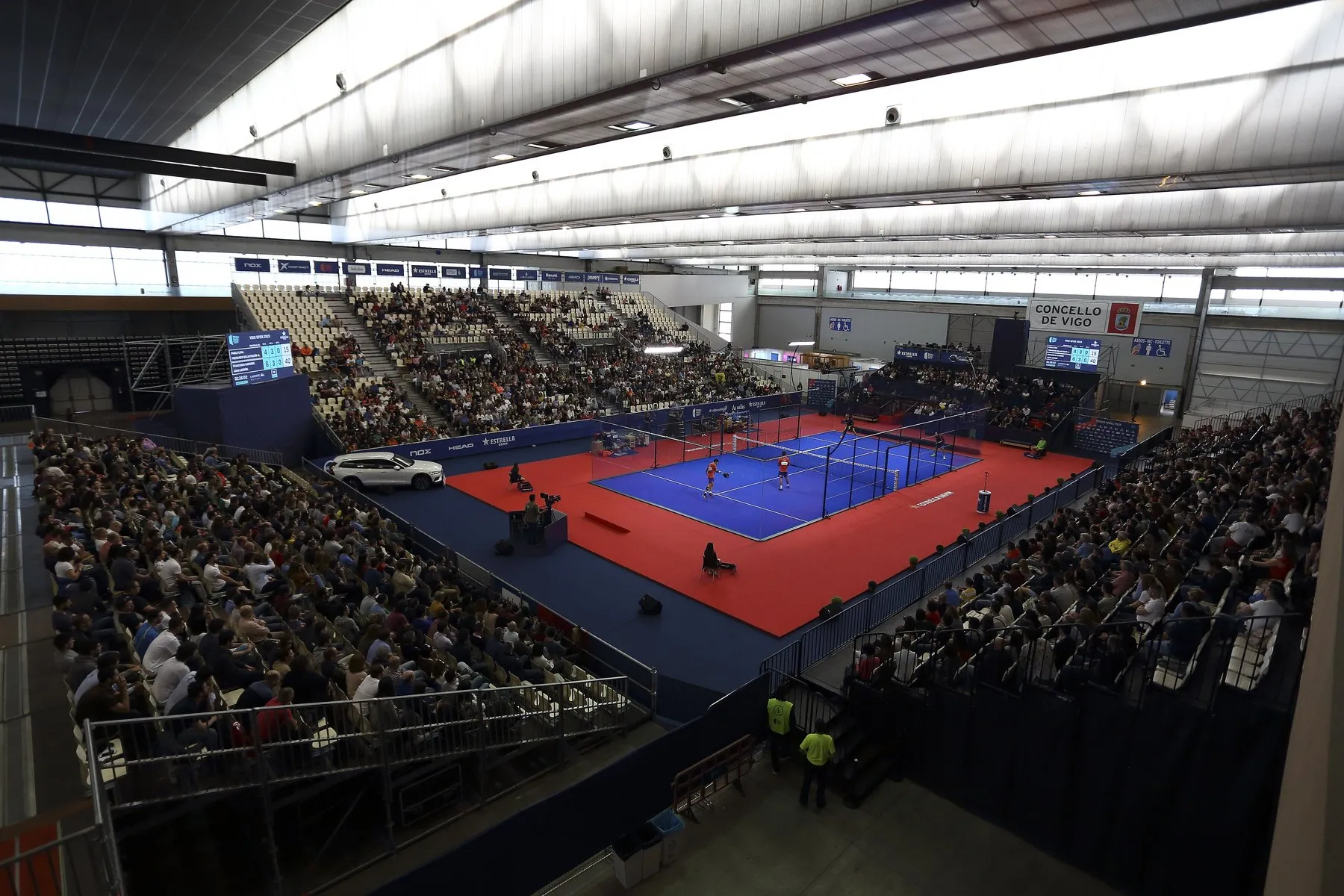 Une salle comble autour d’un court de padel bleu au Vigo Open du World Padel Tour en 2019