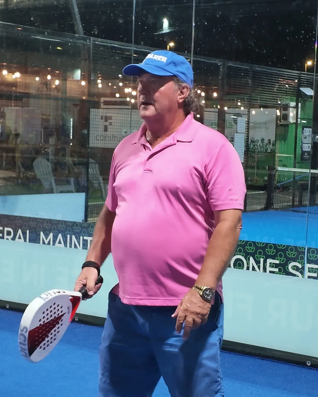 Un joueur en polo rose, raquette SCUD White en main